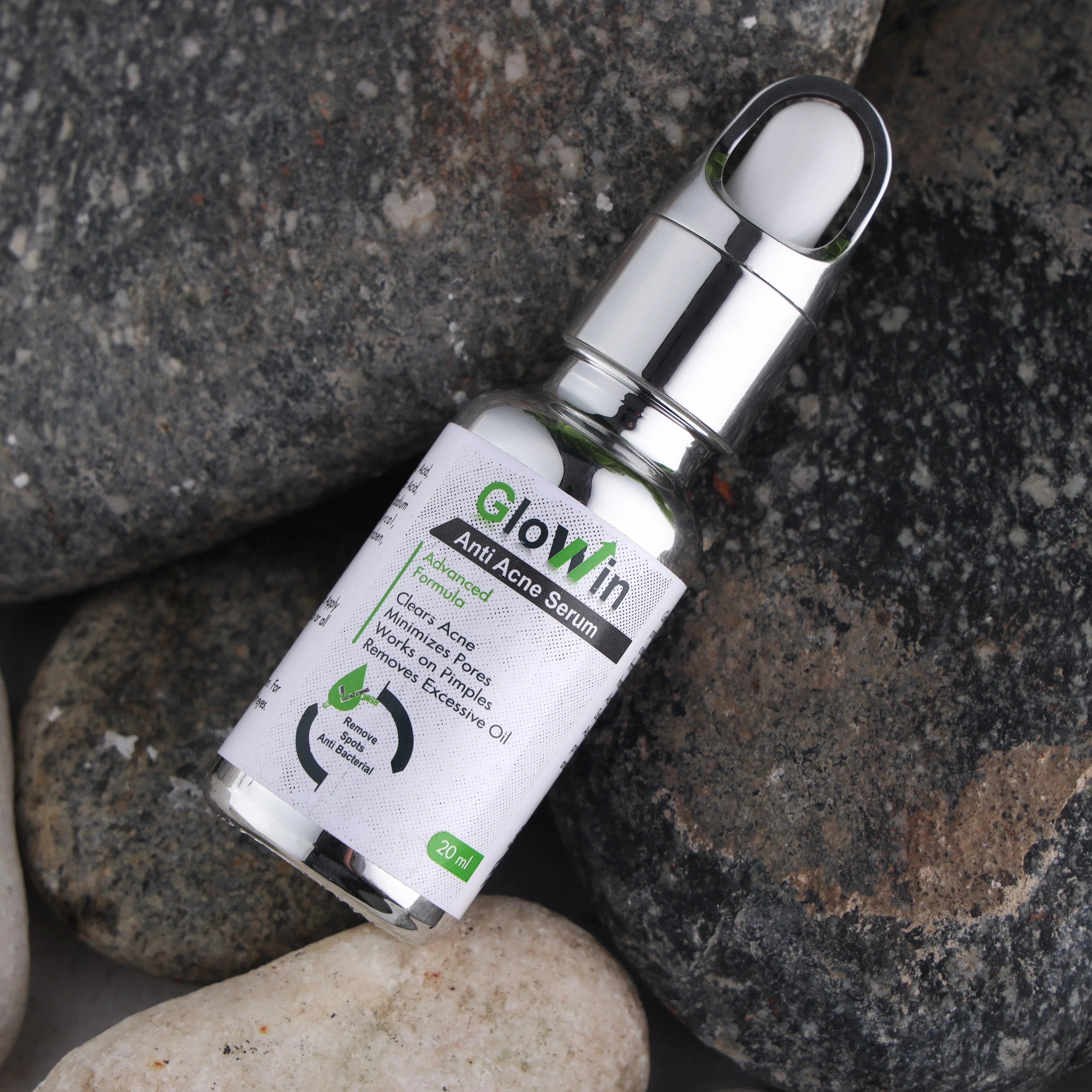 Glowin Anti Acne Serum bottle with dropper on natural stones, skincare product closeup