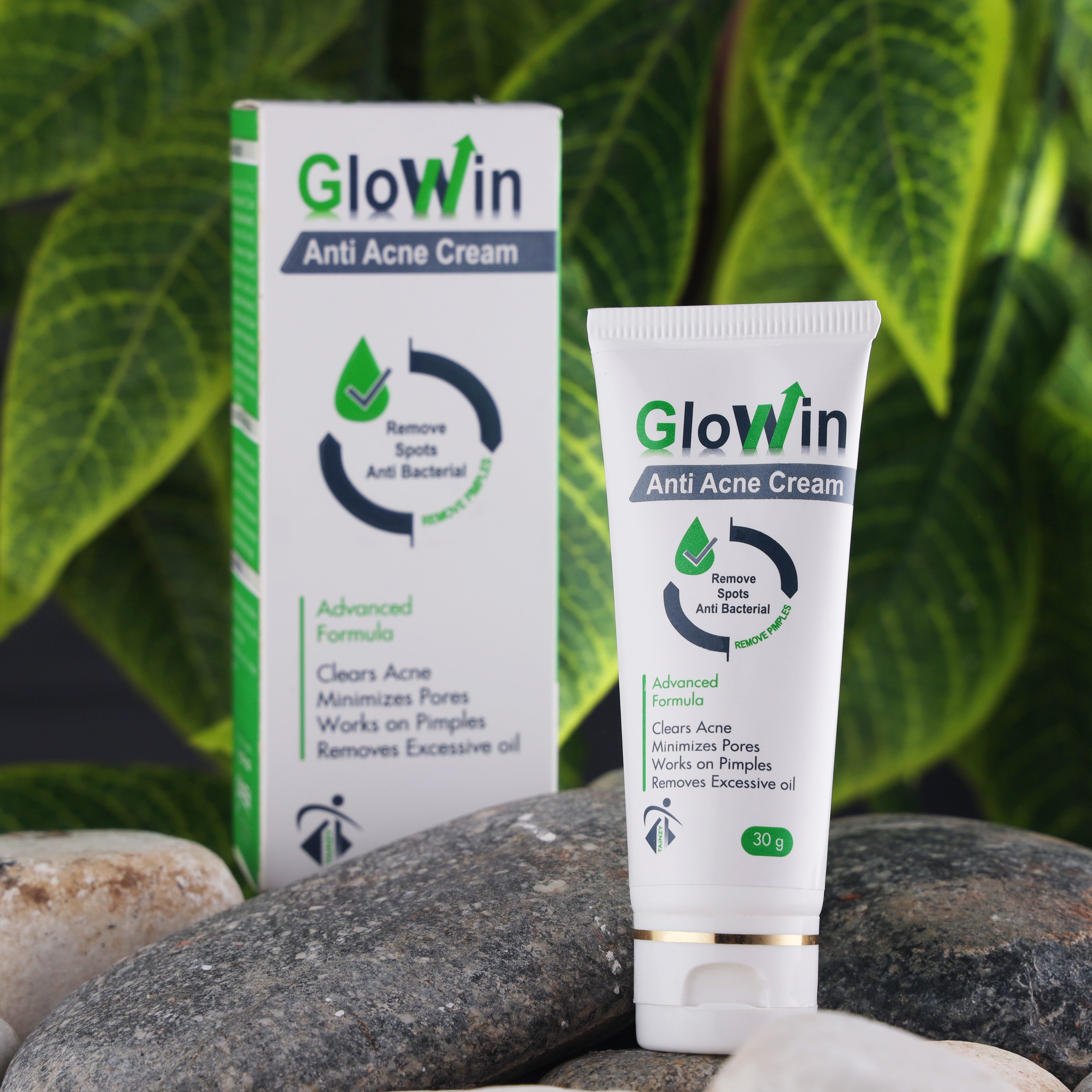 GlowWin anti acne cream tube and box on natural stones with green leaf background