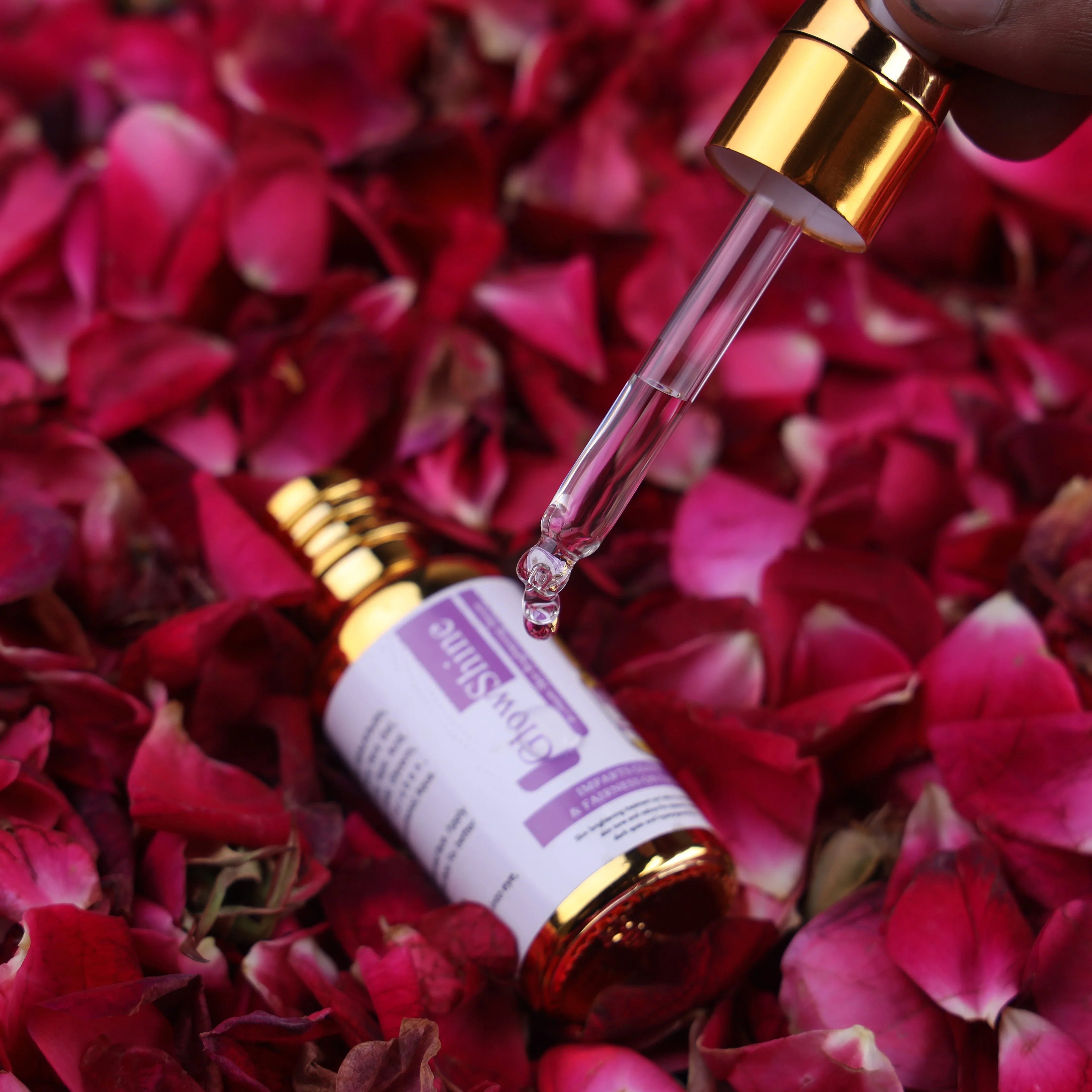 Serum dropper bottle on rose petals, skincare serum for glowing and radiant skin