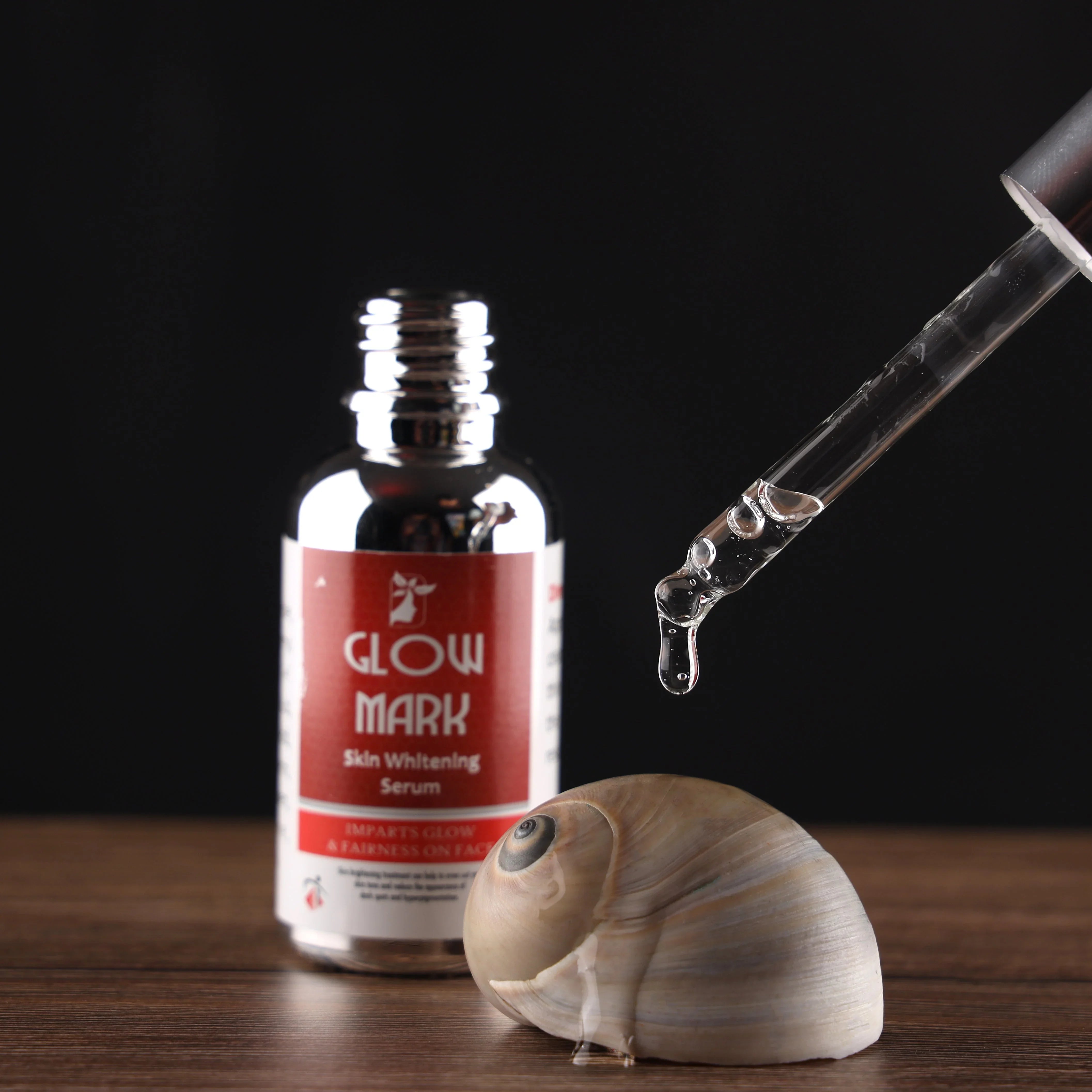 Skin whitening serum bottle with dropper and shell on wooden surface
