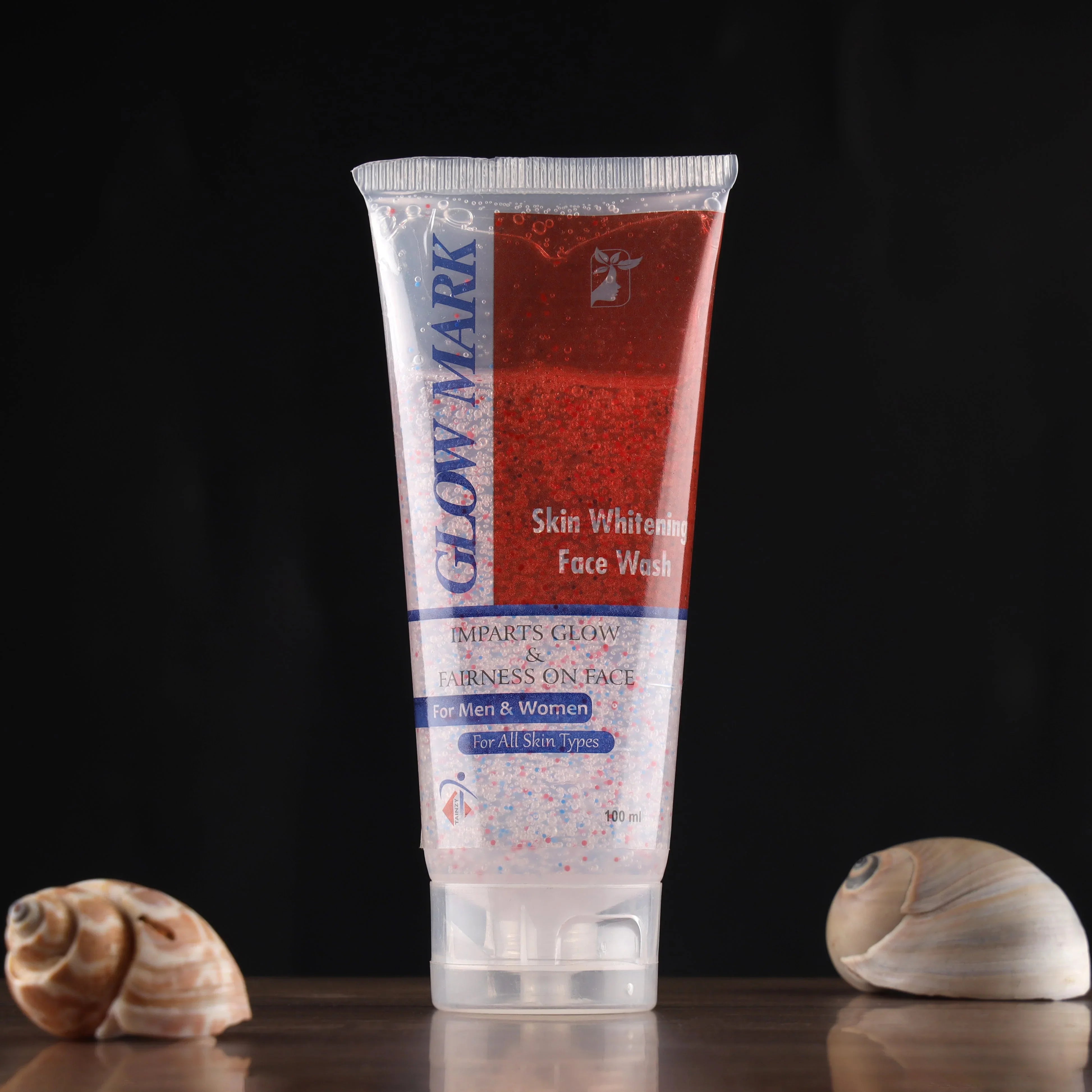Glow Mark skin whitening face wash tube for all skin types on dark background with seashells