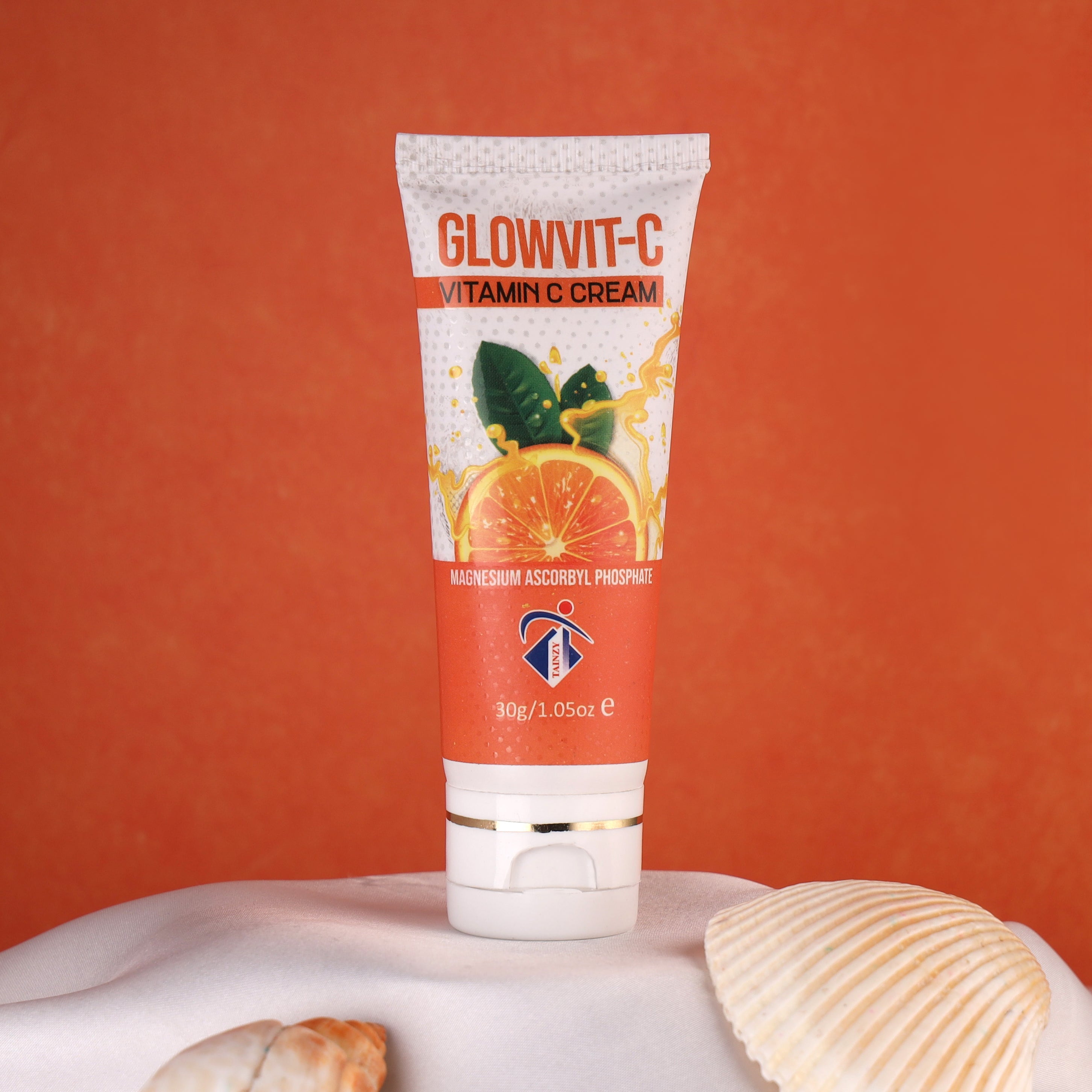 Glowvit-C Vitamin C cream tube with citrus design, skincare product on orange background