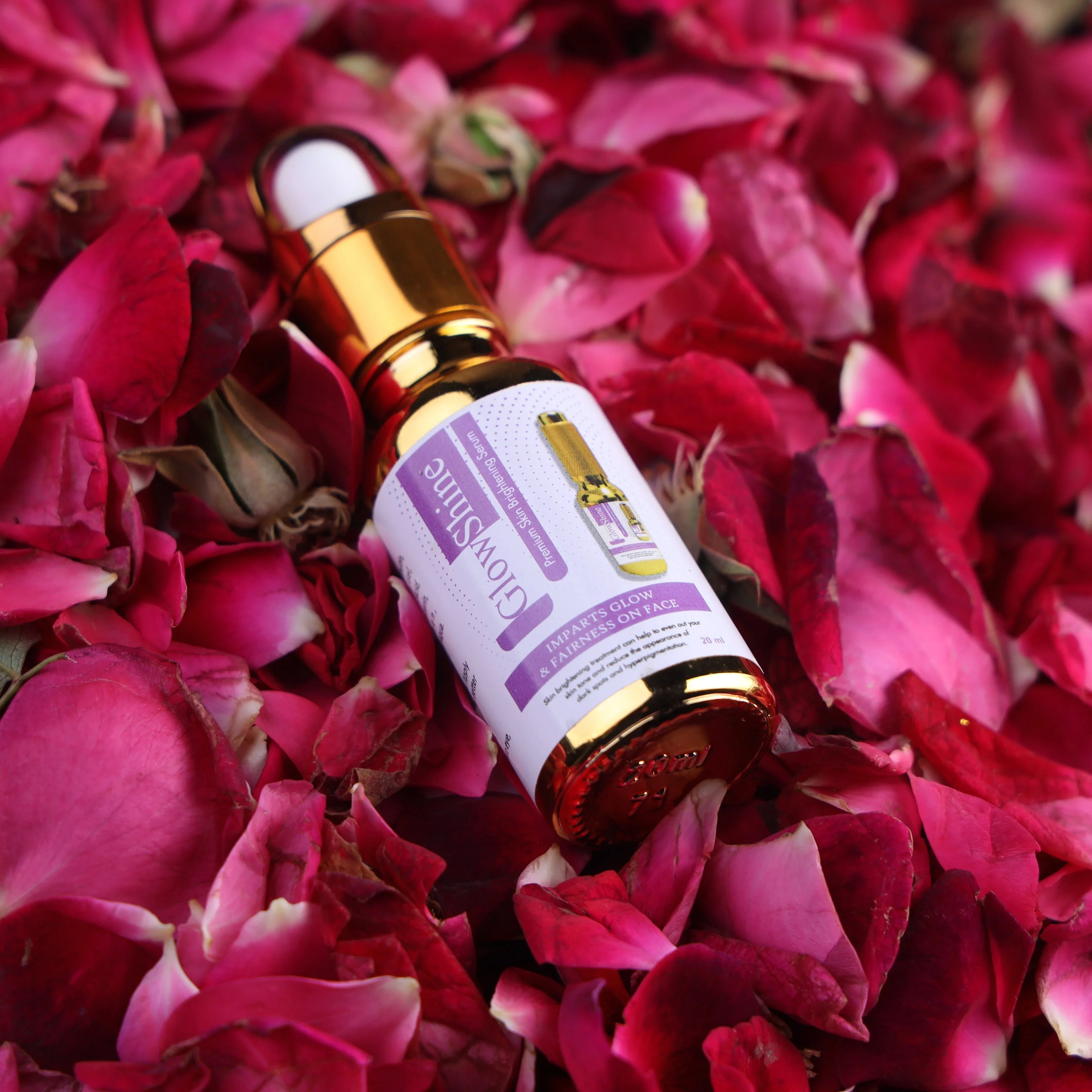 GlowShine serum bottle for skin brightening on pink rose petals