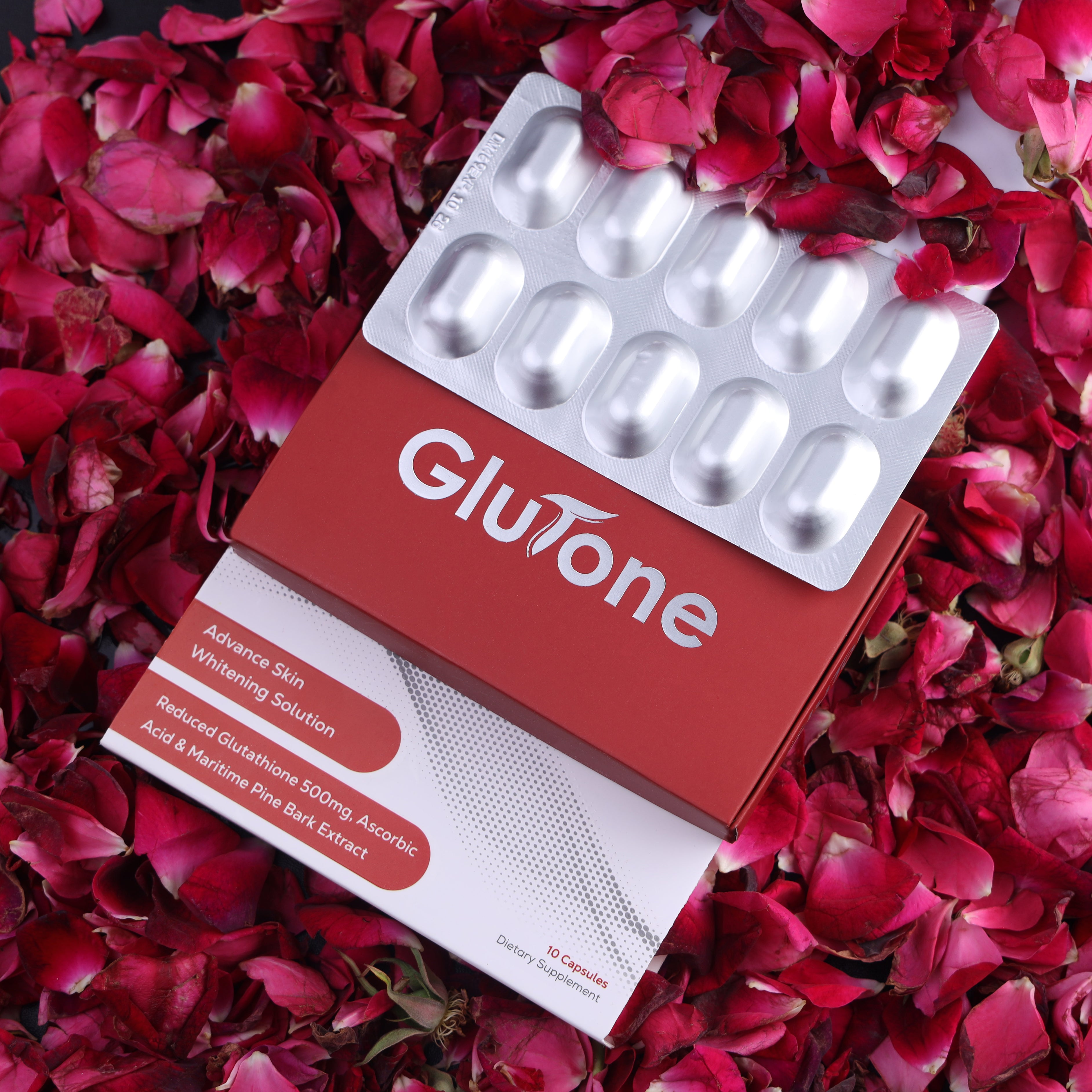 Glutone skin whitening capsules box with blister pack on rose petals, skincare supplement