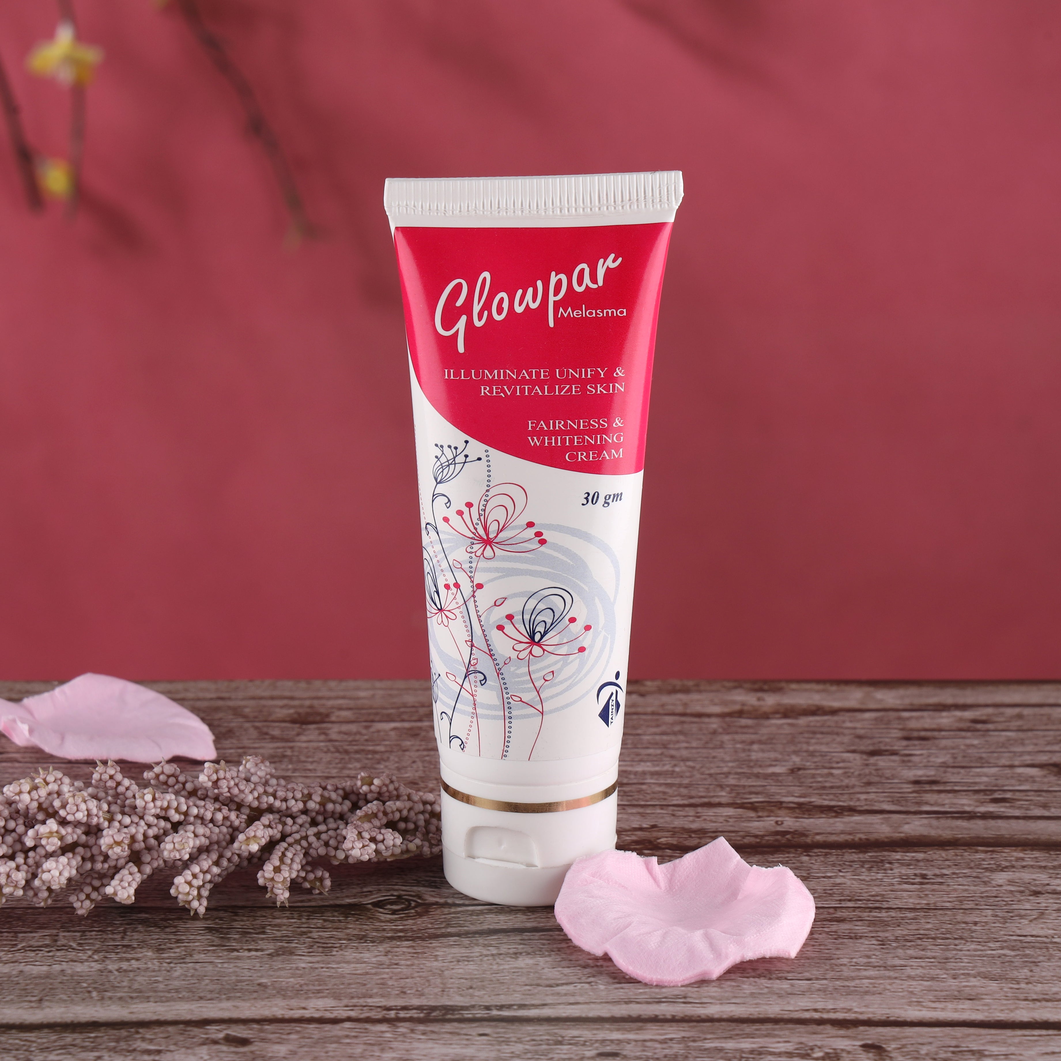 Glowpar Melasma fairness and whitening cream tube on wooden surface with pink petals, skincare product