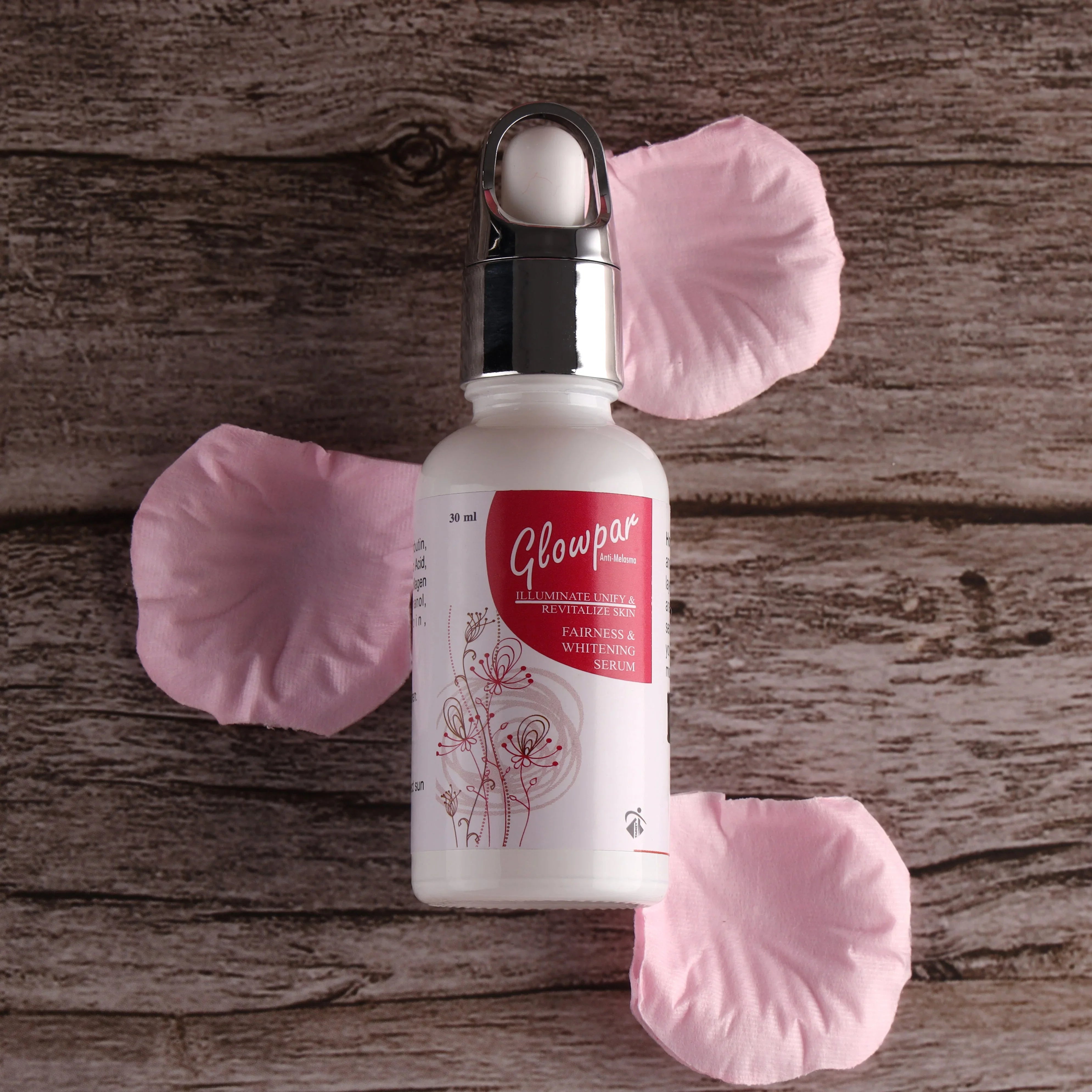 Glowpar fairness and whitening serum bottle with pink rose petals on wooden background